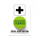 Neon green round pinback button, which reads BACKYARD FARMER in a dark green font. Button is on a Social Alert Backing Card.
