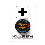 A round black pinback button that reads CHINGA LA MIGRA in goldenrod text And Get The Fuck Out, Of Our Communities in blue text rounded at the top and bottom of the button. Badge is on a Social Alert Button backing card.