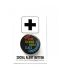 A round black pinback button with lime green. rust read and blue  text that reads SDONT STOP TALKING ABOUT CLASS CONSCIOUSNESS. Button is on a Social Alert Button backing card.