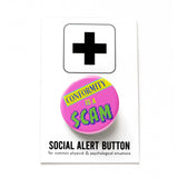 Round bubblegum pink 1.25" pinback button that reads CONFORMITY IS A SCAM in colorful mixed fonts that have a retro 80's vibe. Button is pinned to a Social Alert Button backing card.