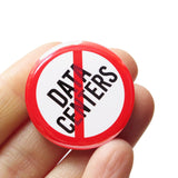A round white button that reads NO DATA CENTERS in black text with a red circle and slash to indicate being against Data Centers. Badge is held in a hand.