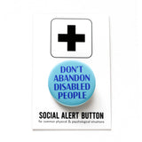 a round 1.25" pinback button with a pale aqua background that reads  DON'T ABANDON DISABLED PEOPLE in a blue-purple font. Button is on a Social Alert Button backing card.