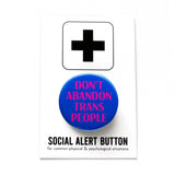 A round blue pinback button that reads DONT ABANDON TRANS PEOPLE in magenta pink. The button is on a black and white Social Alert Button branded backing card.