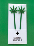 Two tall  1/8" inch thick laser cut green acrylic drink stirrers with the shape of a pot leaf cut out on top, packaged in a CANNABIS COCKTAILS, Dress Up Your Drink white & black package on a green background.