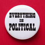 A round white 2.25" pinback button of medium size that reads EVERYTHING IS POLITICAL in chunky black text. Button is on a red background