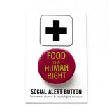 Round burgundy 1.25"  pinback button that reads FOOD IS A HUMAN RIGHT in lime green text.  Pinback button is on a SOCIAL ALERT BUTTON backing card.