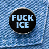 a round black button that says FUCK ICE in a chunky light blue font. Badge is pinned to light blue denim