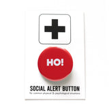a round red pinback button that reads HO! in white text. Button is on a Social alert Button backing card.