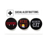Three round pinback buttons lined up on a SOCIAL ALERT BUTTONS backing card. Reading left to right: VAMPIRE in black & red, WERE WOLF in brown & black, and SCARDEY CAT in black & white.