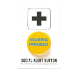 Round, yellow pinback button reads: HEARING IMPAIRED in light blue text. Button is on a white Social Alert Button backing card with a black plus sign at the top.