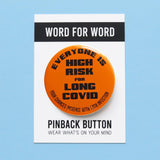 Round bright orange pinback button that reads Everyone Is High Risk For Long Covid, Your chances increase with each infection, in black text. Button is on a Word For Word branded backing card that reads Wear What Is On Your Mind