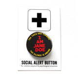 Round black pinback button that reads I AM JANE DOE  in neon orange text, and yellow curving text  reading: the tides are Turing, the silence is ending. The button is pinned to a Social Alert Button backing card.
