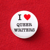 Round white pinback button with a bright read heart that reads I LOVE QUEER WRITERS in class black type. Love is induced by red heart. Button is pinned to a red sweatshirt