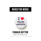 Round white pinback button with a bright read heart that reads I HEART TRANS ARTISTS in classic black type. Button is on a white backing card, with a black band at the top with WORD FOR WORD in white text. Below reads: PINBACK BUTTON, Who We Really Love.