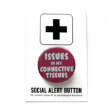 A burgundy pinback button that reads ISSUES IN MY CONNECTIVE TISSUES in a jagged cream and light blue text. Button is pinned to a Social Alert Button backing card.