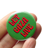 A round olive green pinback button that reads LET GAZA LIVE in a red art nouveau font. Button is held in a hand.