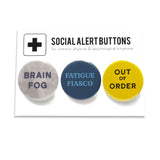 3 round multi-colored pinback buttons lined up on a SOCIAL ALERT BUTTONS backing card. Reading left to right: Brain Fog, Fatigue Fiasco, Out of Order