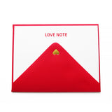 A white note card with LOVE NOTE embossed in red gloss type at the top, with a red envelope, with a tiny gold heart at the close of the triangle.