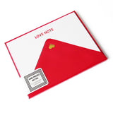 A white note card with LOVE NOTE embossed in red gloss type at the top, with a red envelope, with a tiny gold heart at the close of the triangle. The stack has a sticker in the corner that reads HAND-PRESSED HOT FOIL, 6 flat notecards & envelopes