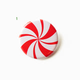 A red & white pinwheel spiral pinback button that looks like a peppermint candy. a number 1 in green indicates Design 01