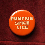 Round orange pinback button that reads Pumpkin Spice Vice in a cinnamon creme text.  Button pinned to redwood suede  leather jacket.