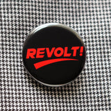 round black 1.25" pinback button that reads REVOLT! in thick red type. Button is pinned to a houndstooth garment.