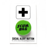 Round bright lime green pinback button with chunky black text reading SCUM BAG. Button is pinned to a Social alert Button backing card. 