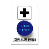 Round navy blue pinback button with vivid light blue text reading SPACE CADET. Pinned to a Social Alert Button backing card.