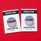 Two pinback buttons separated by a perforated line to tear & share. Button the left reads THELMA, button on the right reads LOUISE. Both buttons have a pale teal to white ombre with red text. On red background.