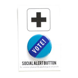 Blue round pinback button that reads VOTE! in white across a navy blue diagonal strip. Button is a Social Alert Button backing card.