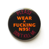 A round black pinback button that reads WEAR A FUCKING N95! in red text, in the center, and top & bottom curve orange text that reads PLEASE DON'T KILL ME. 