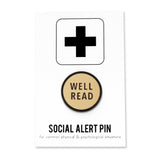 Round cream enamel pin that reads WELL READ in sans serif font on a Social Alert Pin backing card.