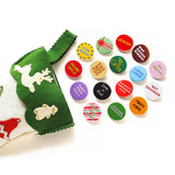 A bunch of shiny round multi-colored pinback buttons coming out of a green felt stocking: Buttons read -- Drunk Uncle, Egg Nog Fog, Star Baker, Sugar Plum Fairy, Lump of Coal, Naughty/Nice, Re-Gifter, Present Peeker, Jewish, Hot Cocoa Sipper, Latke Lover, Gay Apparel, Nut Cracker, Fruit Cake, Candy Cane Licker and more