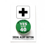 A round green 1.25" pinback button that reads YES ON PROP 40: One time 5% Wealth Tax, Only On Billionaires,  in white text. Button is on a Social Alert Button backing card.