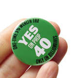 A round green 1.25" pinback button that reads YES ON PROP 40: One time 5% Wealth Tax, Only On Billionaires,  in white text. Button is held in a hand.