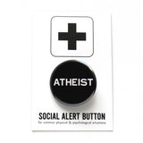 Round black pinback button that reads ATHEIST in white text . Button is on a Social Alert Button backing card.