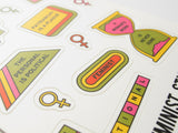 Close up of a sheet of feminist themed stickers in yellow, moss green pink and orange. Phrases include Feminist With A To-Do List, Equal Pay, The Personal Is Political, Patriarchy Is A plague, A Woman's Work   Is Never Done, Intersectional and little women's symbol stickers. Sticker Sheet is held up by a hand.
