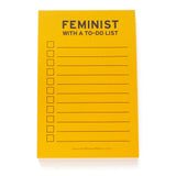 Lined notepad that reads FEMINIST WITH A TO-DO LIST at the top in black text. The paper is goldenrod yellow color. Checkboxes to the left, lines to write to-do list, to the right.