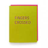 Rich lime green greeting card with magenta hot foil emboss that reads FINGERS CROSSED in a thin sans serif font. With Deep pink matching envelope.