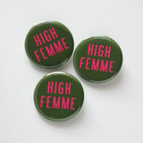 three round green pinback buttons that read HIGH FEMME. Pink text with a red shadow on an olive green background. ]