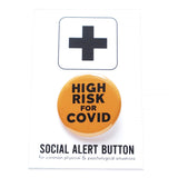 Round pinback button that says HIGH RISK FOR COVID.  Button is neon orange with black text. The button is on a black and white Social Alert Button backing card with a black plus sign at the top.
