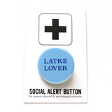 round light blue 1.25" pinback button that reads LATKE LOVER in dark blue serif text.  Button is on a Social Alert Button backing card.
