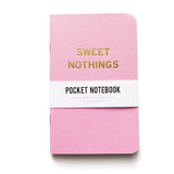 A small bubble gum pink pocket notebook with rounded corners, gold embossed text reading SWEET NOTHINGS, with a white belly band that reads Pocket Notebook.